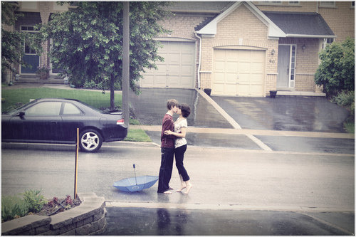 romantic couple kissing in the rain. seem to faze this couple;
